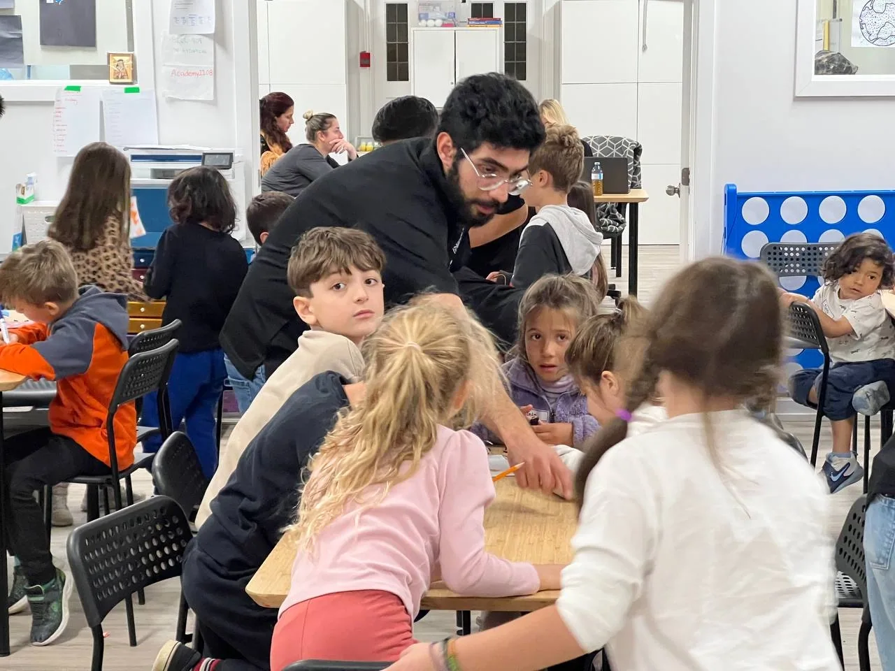 Instructor guiding learners at a robotics workstation